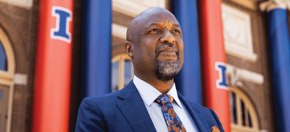 Isbell standing outside in front of building with orange and blue banners