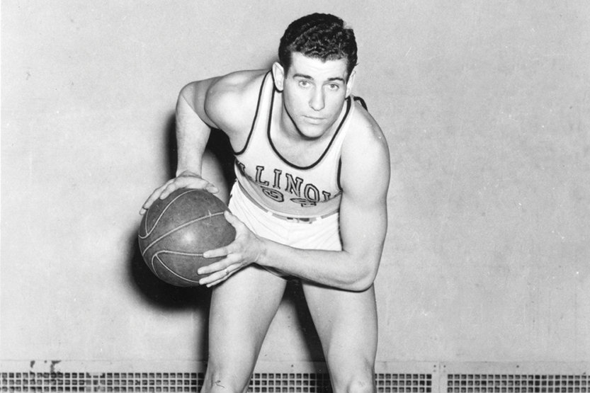 A posed shot of Dike Eddleman in his uniform holding a basketball.