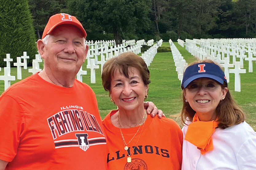 Jay Stortzum, Winnie Stortzum and Cindy Mark pose in front of white cross grave markers on Normandy, France.