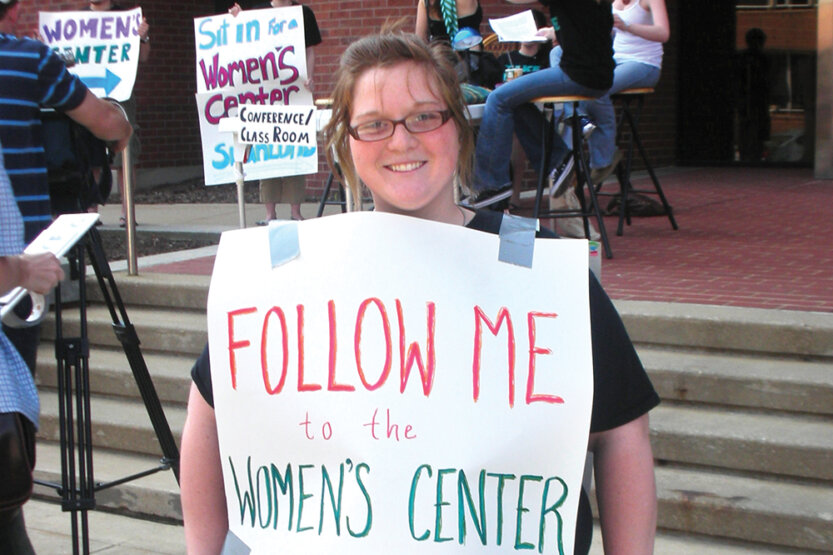 Kaytlin Reedy-Rogier holding Womens Center Sign