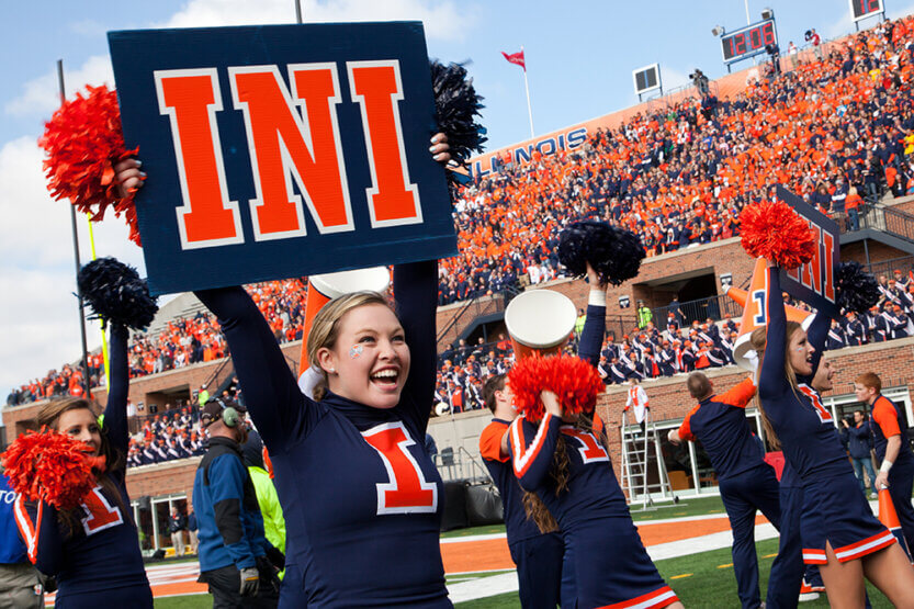 Cheerleader holding "INI" sign