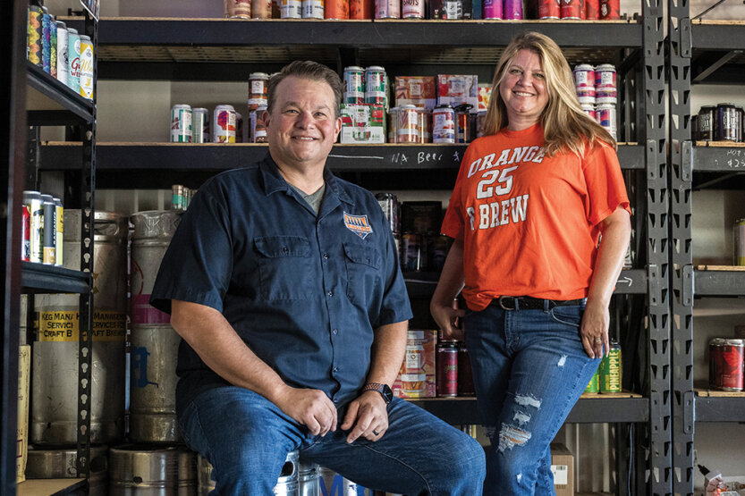 Eric and Carrie Schmidt among shelves of beer