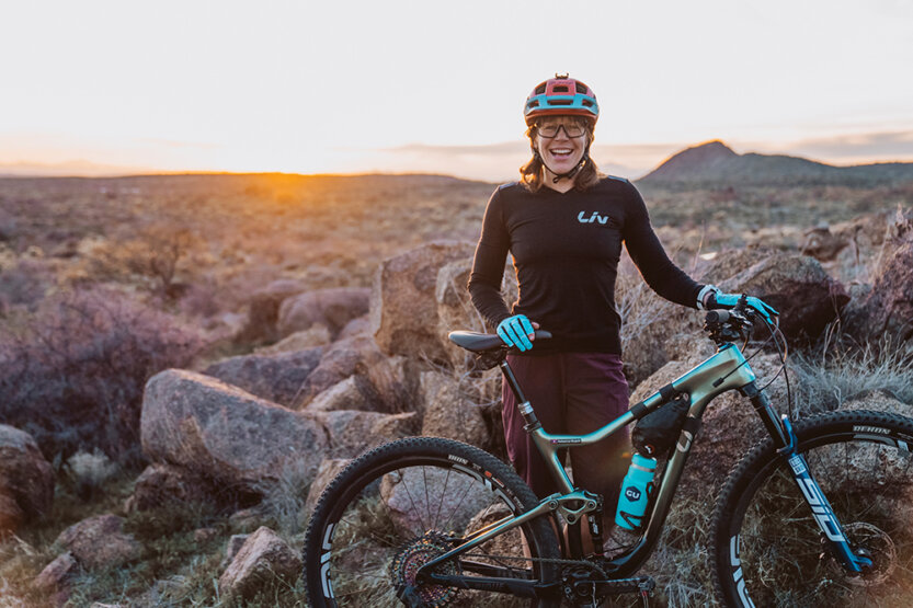 Rebecca Rusch in rugged, arid terrain with her mountain bike