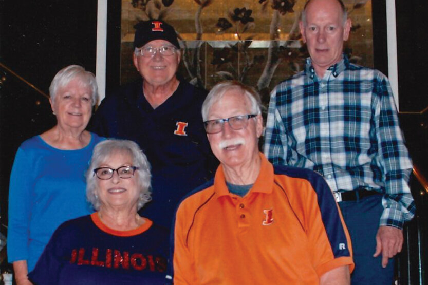Group of alumni pose on steps