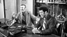 Two men seated at a table with microphones