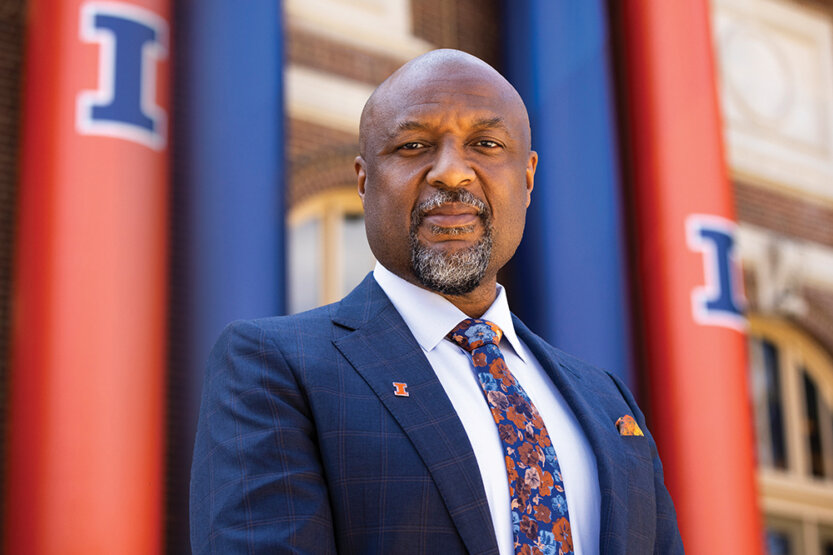 Isbell standing outside in front of building with orange and blue banners