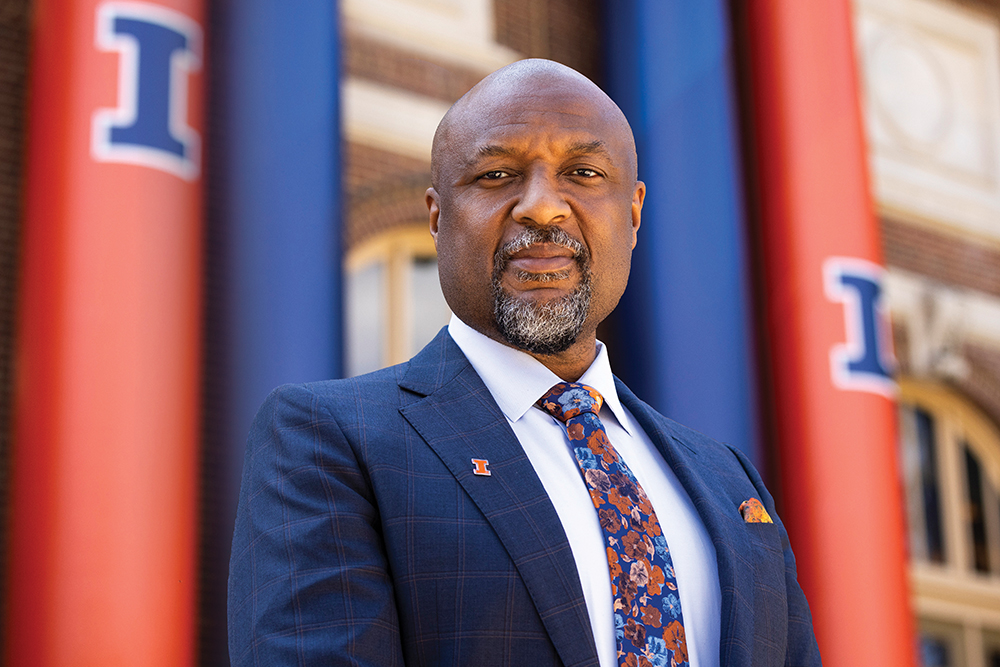 Isbell standing outside in front of building with orange and blue banners
