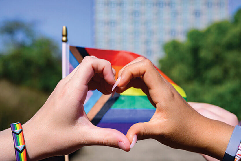 Pride flag with heart hands