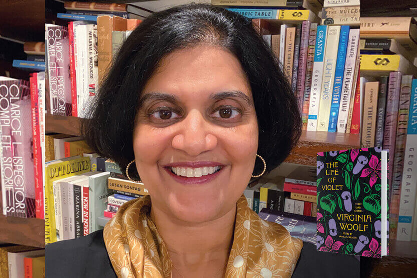 Urmila Seshagiri in front of a bookshelf with her book