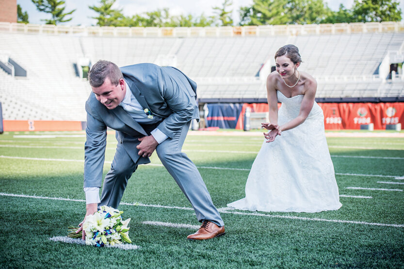 Alex hiking a bouquet of flowers to Samantha on a football field