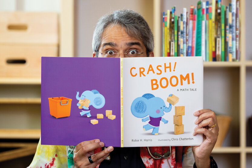 Dipesh Navsaria peeking over the top of a children's book
