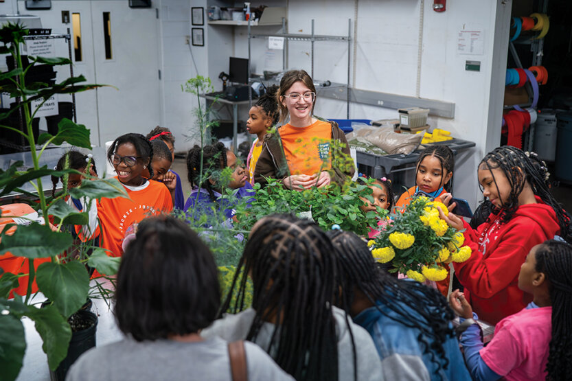 Young students and parents gathering in a lab environment.
