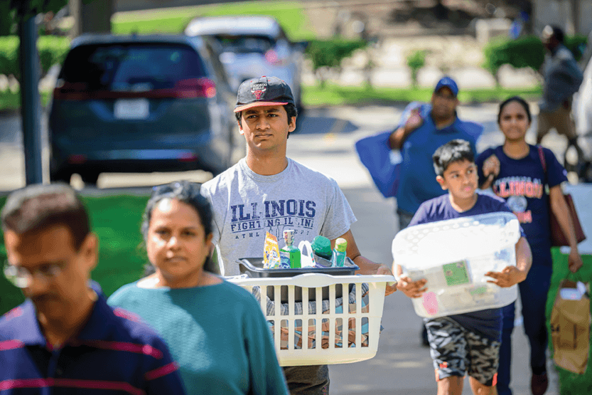 Student carrying a laundry basket outside